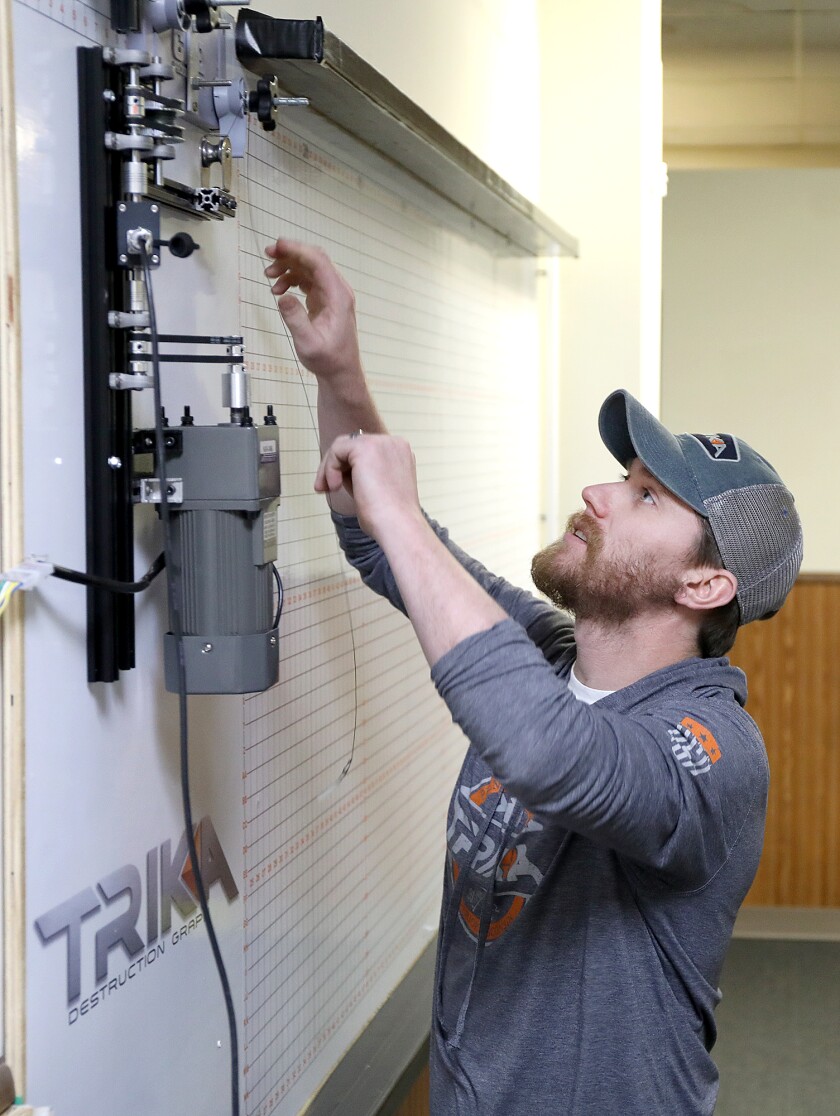 Travis Tacheny gets ready to test the limits of a Trika rod at the company’s headquarters on Tower Avenue in Superior