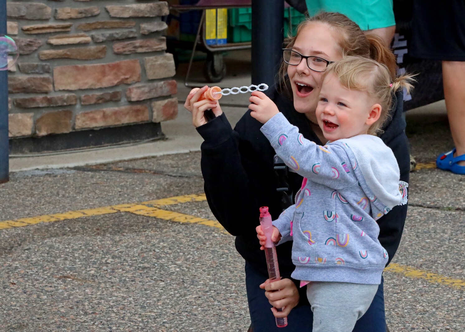 A bubble floats out of frame as a woman and girl watch.