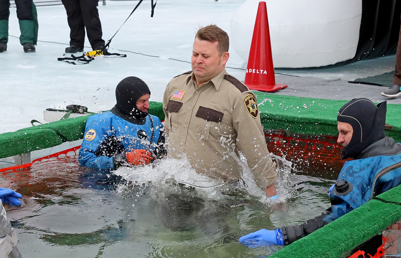 People jump into the water during the Polar Plunge event on Pelican Lake.