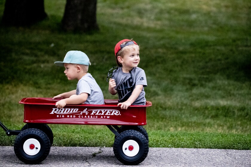 Camden Leitch, 2, left, rides shotgun with Graham Schwieger as Camden's father Griffin Leitch pulls them around Robbins Island Regional Park during Rockin' Robbins in Willmar on Tuesday, July 26, 2022.