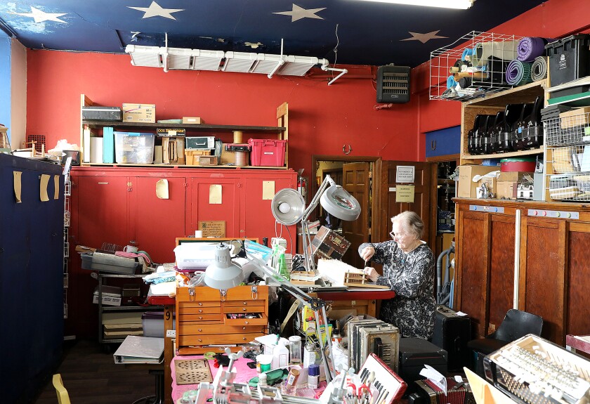 Helmi Harrington, A World of Accordions Museum president and curator, sits alone as she repairs an accordion in the basement of the Harrington ARTS Center