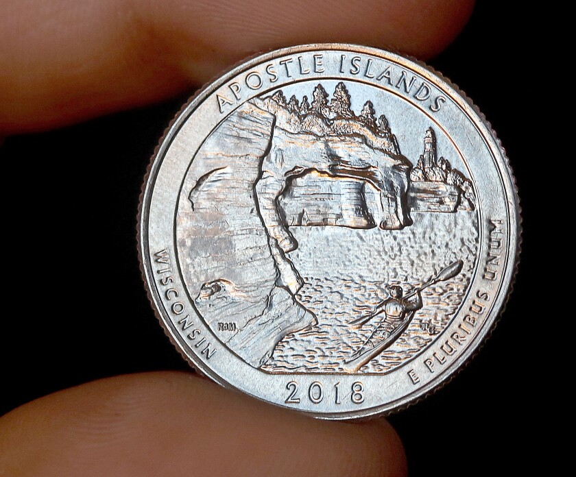 The new Apostle Islands quarter features a visitor kayaking in the park with a backdrop of the Devils Island sea caves and lighthouse. Bob King / Forum News Service