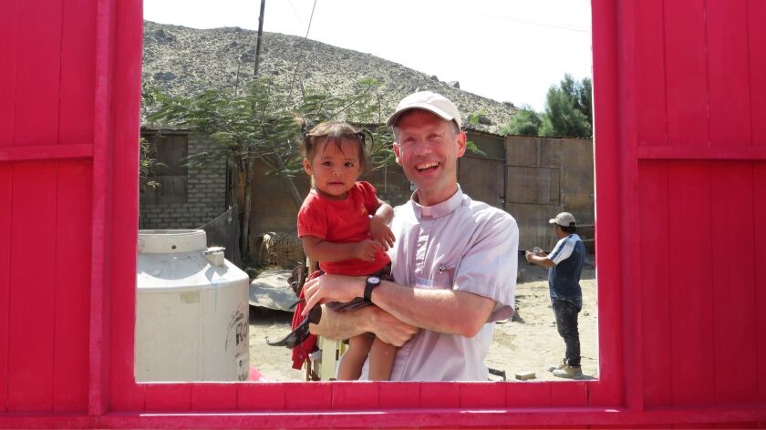Kotrba_Fr. Ross with Natalia, a child of the family who received the new home, Cambio Peunte, Peru.jpg