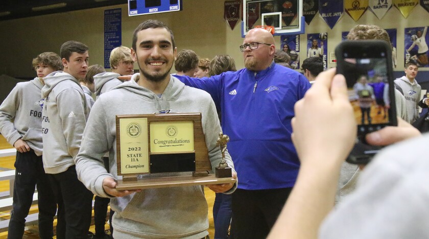 football pep rally holding trophy 111415.jpg