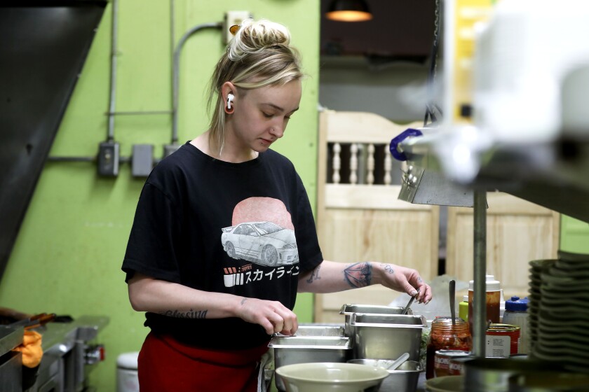 A woman helping to make a meal in a kitchen.