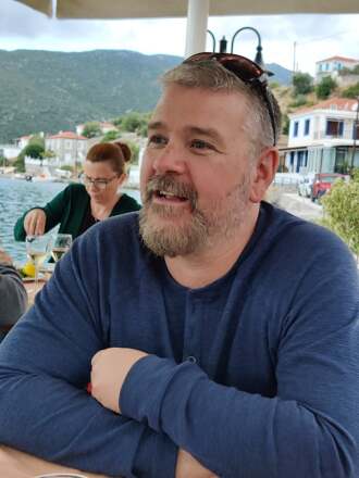 A beared man in a blue shirt.