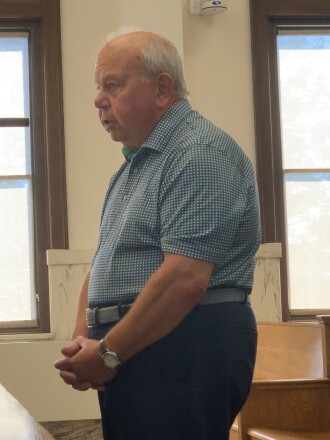 A man speaks at a microphone in the Crow Wing County boardroom.