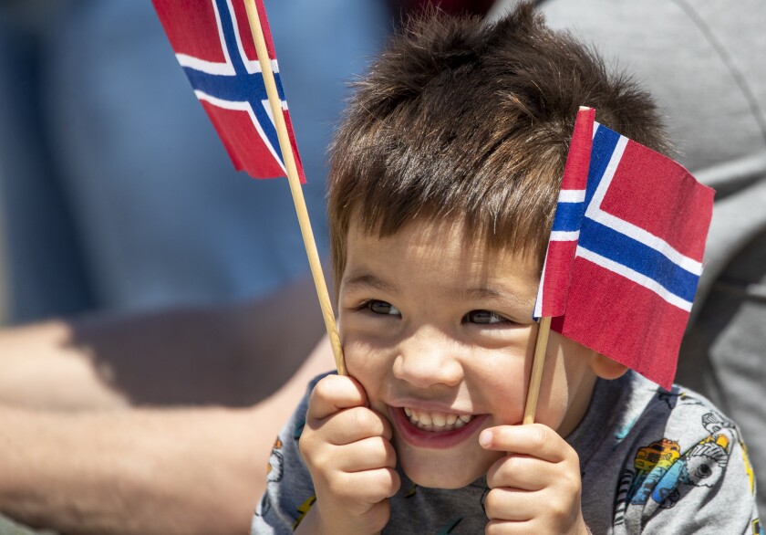 Jonathan Stevenson, 3, hoists a pair of Norwegian flags while waiting for the Uff-da parade to begin during the 16th annual "A Taste of Syttende Mai," Saturday, May 14, 2022, in Milan.