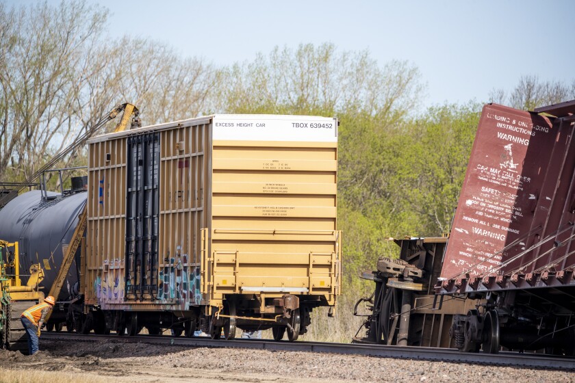 BNSF Railway employees work to pull train cars back onto the tracks just east of Pennock the morning of Friday, May 13, 2022, after strong winds the night before derailed a series of train cars.