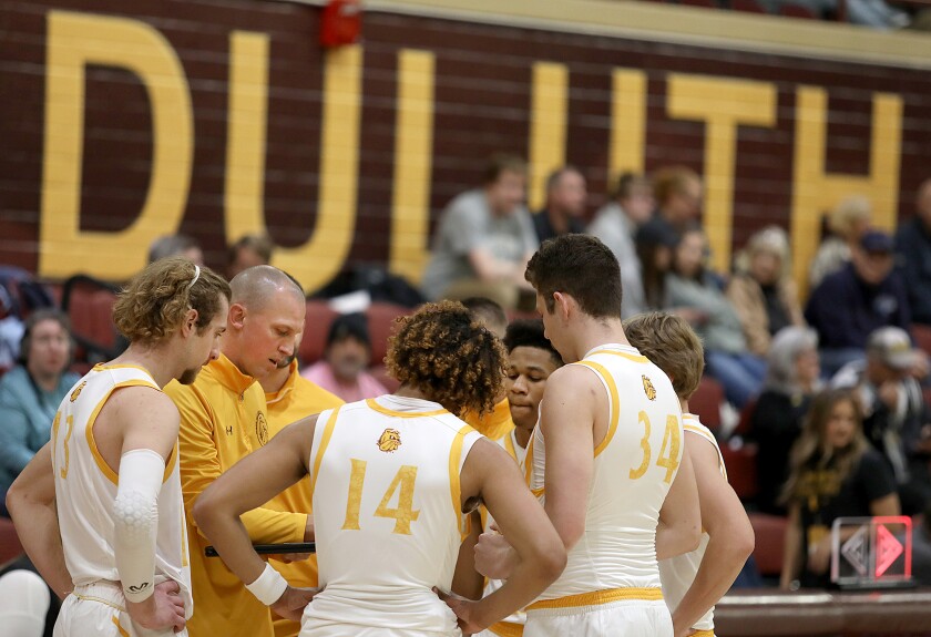 Minnesota Duluth head basketball coach Justin Wieck talks to his players during a timeout