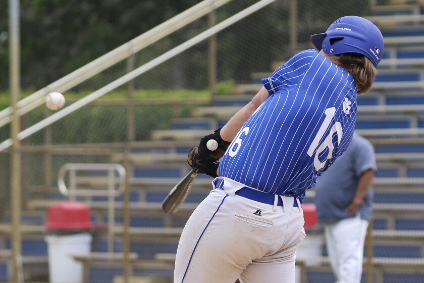 High school baseball players play on outdoor field on sunny day