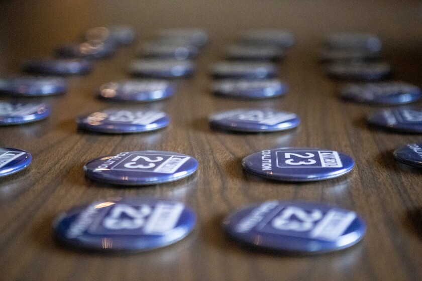 Buttons for the Highway 23 Coalition sit out on a table for people to pick up while attending the groundbreaking ceremony at Roadside Tavern Banquet Hall in Roscoe on Friday, May 6, 2022.