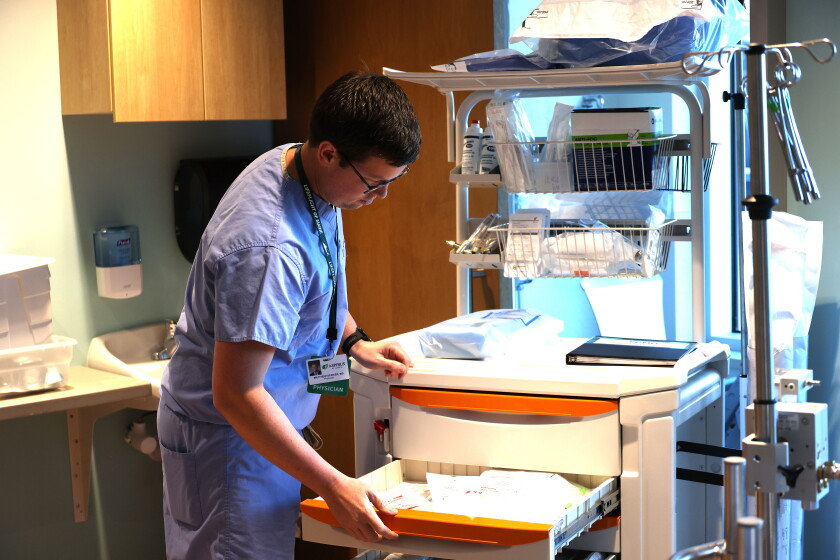 Doctor looks in supply drawer