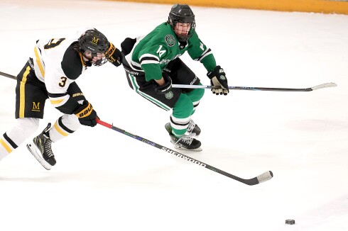Player race to the puck.