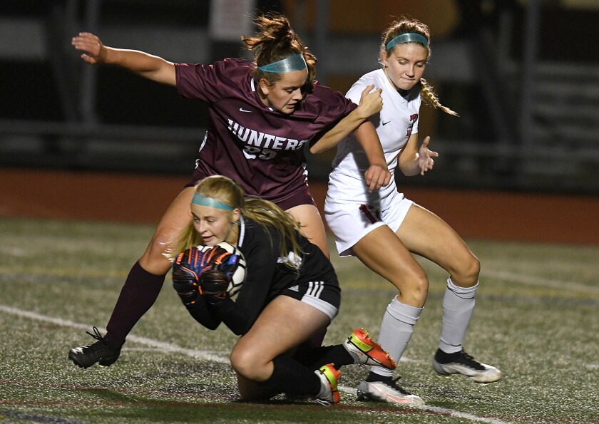 Duluth Denfeld keeper Cayley Larsen (98) stops the ball as Lucy Bell (25) boxes out Duluth East’s Grace Karakas (13)