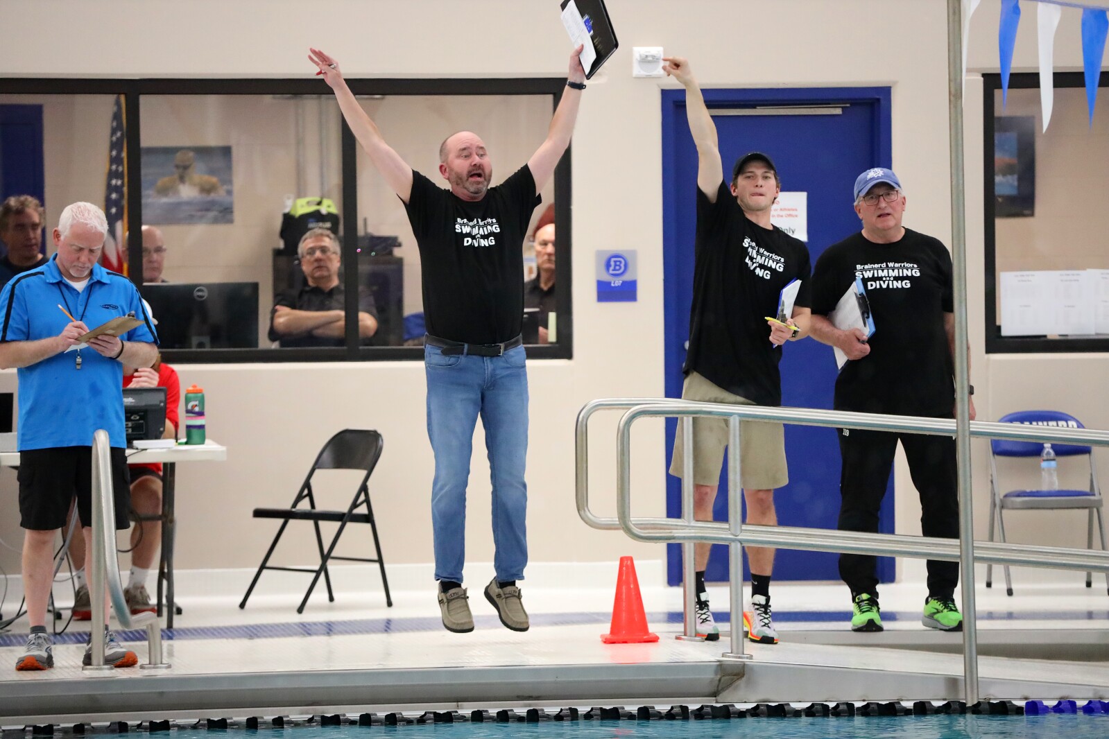 Brainerd coaches jumping and yelling at the side of the pool.