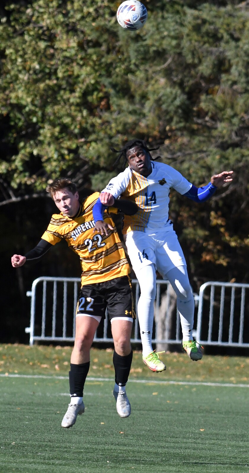 Arsino Hamilton (14) de Scholastica de Kingston, Jamaica, mira cómo le sale el balón de la cabeza mientras choca con Drake Schramm (22) de UW-Superior