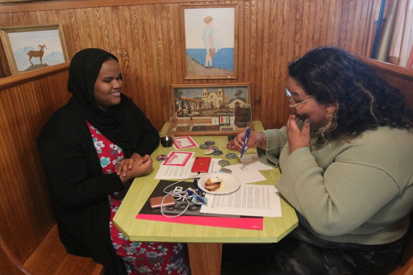 Jazmynn Ahmed on left and Lexx Francis writing letters to state legislators to oppose a pair of bills targeting sexual explicit material in books in public libraries while at Zandbroz Variety on Monday, March 13, .jpg