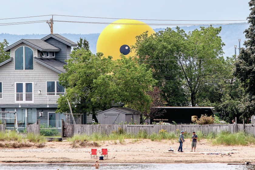 t081816 --- Clint Austin --- austinTALLSHIPS0819c17 --- Mama duck looms over unsuspecting beach goers at Park Point during the Tall Ships Duluth Parade of Sail Thursday afternoon. Mama duck is a 61-foot tall, 12-ton inflatable rubber duck. (Clint Austin / caustin@duluthnews.com)