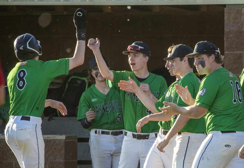 Bulldog Max Ahtmann is congratulated by his Paynesville teammates after scoring a run against the KMS Fighting Saints on Thursday, May 26, 2022.