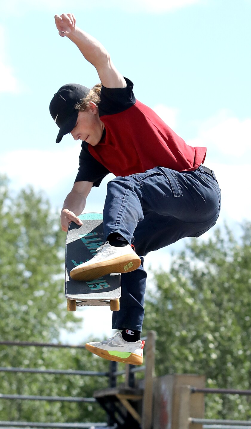 Graham Ward grabs his board as he lands a trick