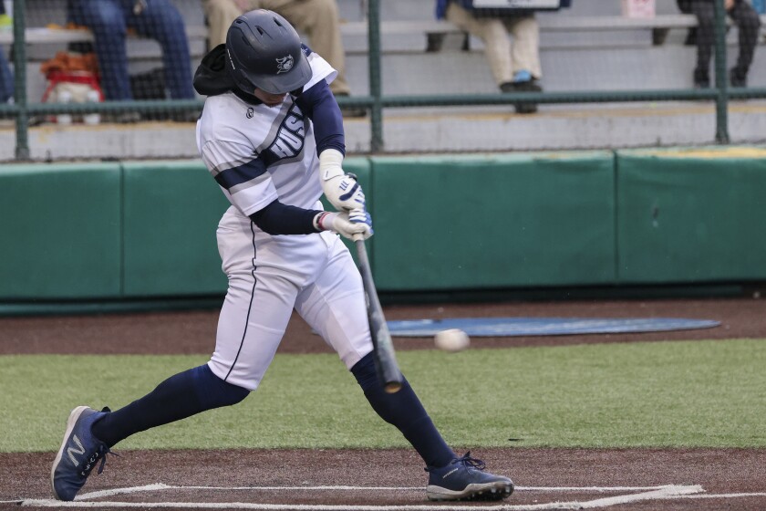 Baseball players in white and blue uniforms playing a game at outdoor stadium