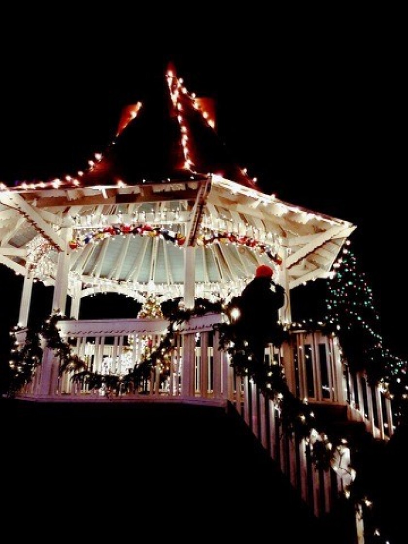 Holiday lights line the outside of a gazebo.