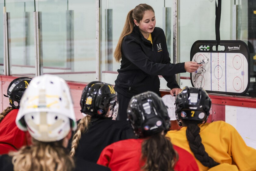 Women hockey coaches work with team