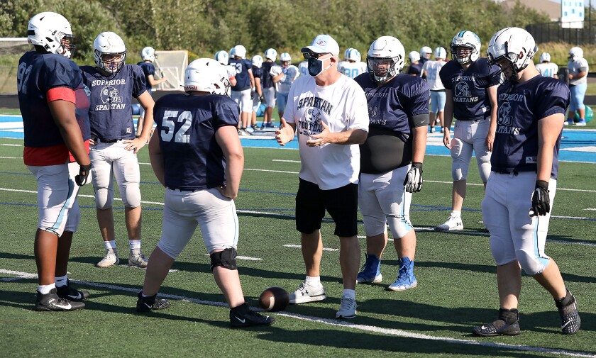 Superior assistant coach Rick Kennelly talks to the line during practice