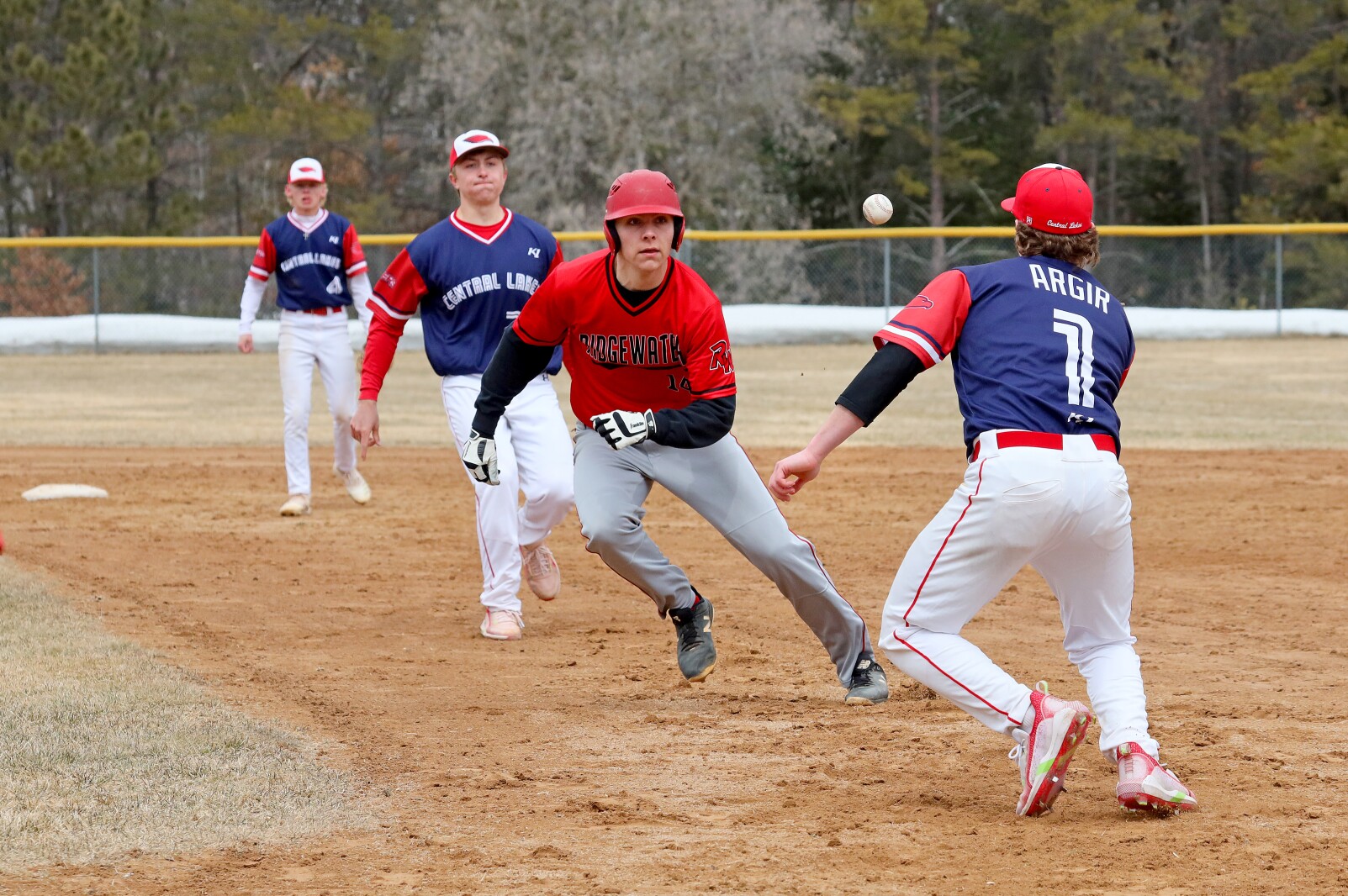 Central Lakes College's Mason Argir, front, and Derin Gaudette, rundown Ridgewater's Bennette Knapper Sunday, April 3, 2022, at Paul C. Findorff Athletic Complex in Brainerd.