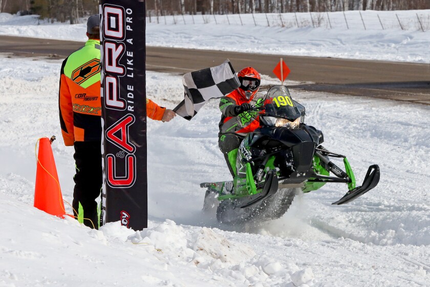 Snowmobilers race.