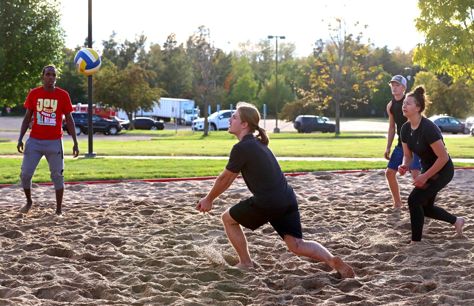 Volleyball players compete outside on the sand volleyball courts at CLC.