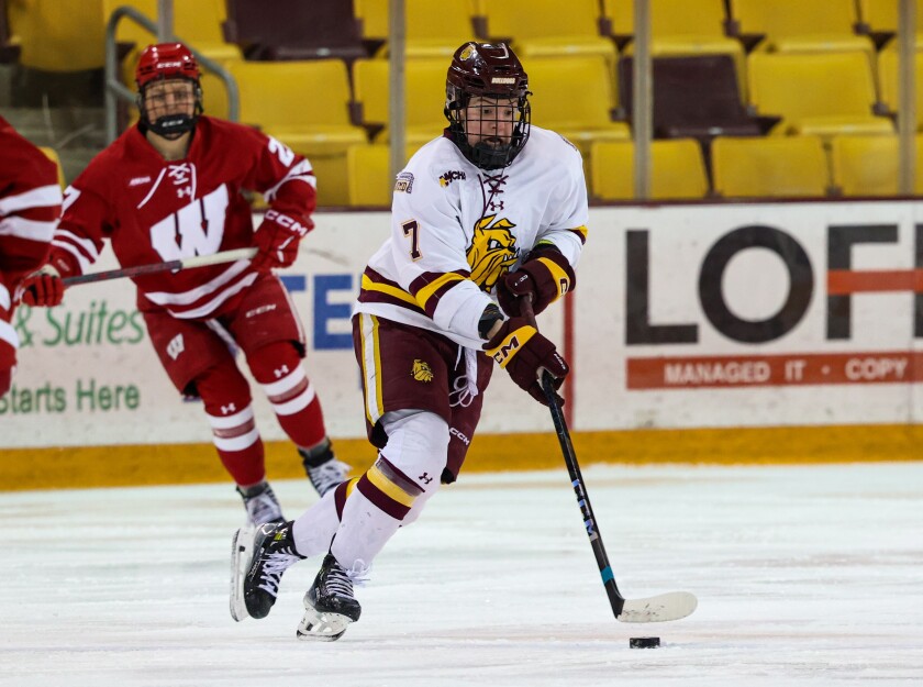 Hockey player skates with puck