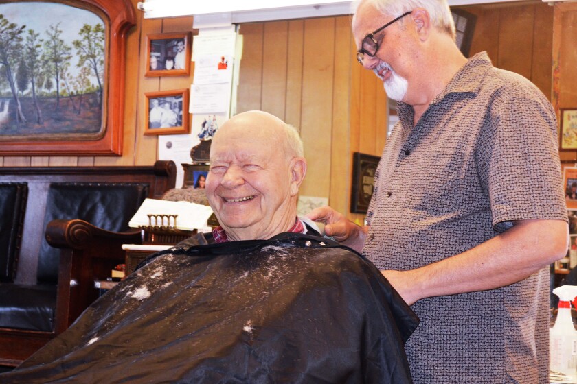 The owner of Kyle’s Barbershop, Kyle Nelson, cuts Dwaine Johnson’s hair. The barbershop has become a place for musicians to hang out, while also getting hair cuts. (Beth Leipholtz | Echo Press)