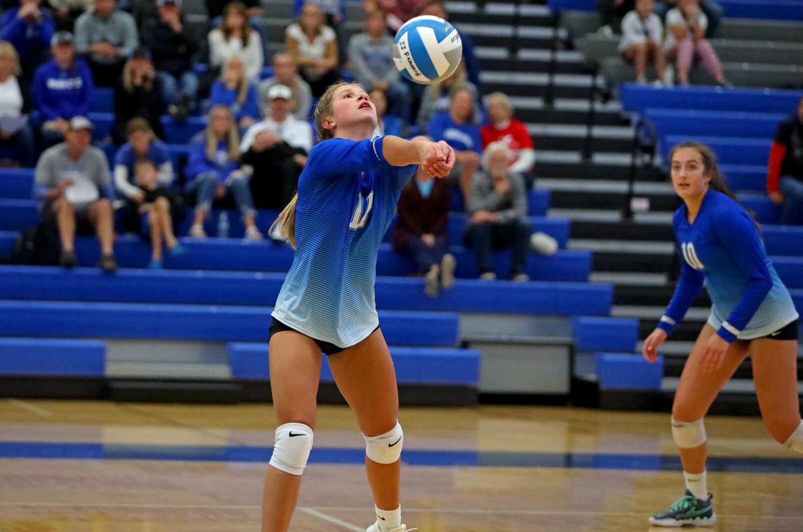 Volleyball player bumps the ball.