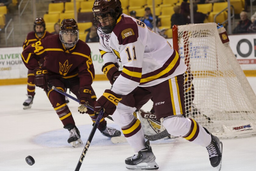 College hockey players play game in indoor arena