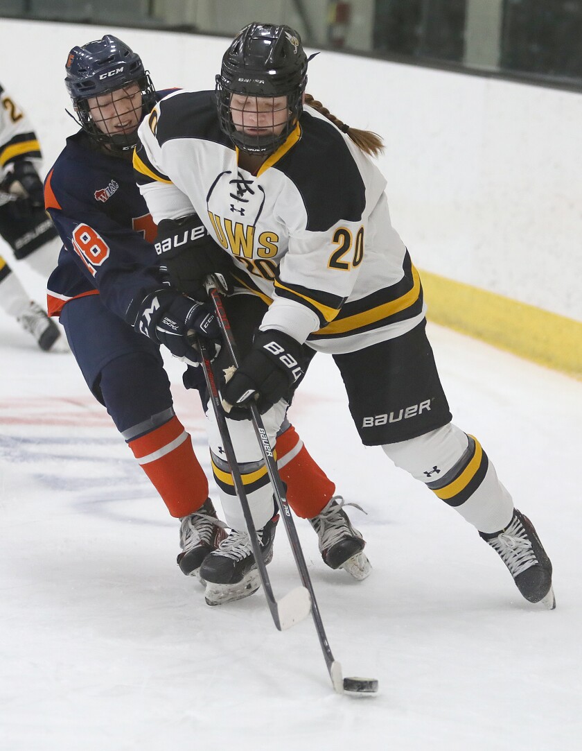 UW-Superior’s Jordann Swingle (20) keeps the puck away from Northland’s Yvonne Durfee (18)