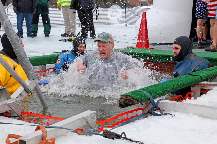 People jump into the water during the Polar Plunge event on Pelican Lake.
