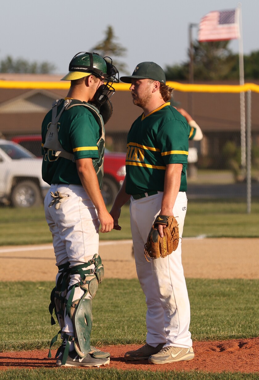 Adrian A's Pitcher Mike Preuss has a conference on the mound with Catcher Garrett Sarringar as the bases get crowded during a Wednesday evening game hosted by Worthington Cubs.