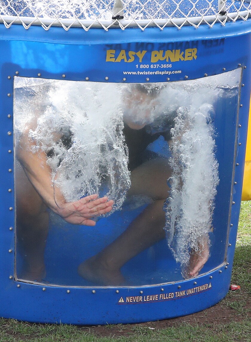 Superintendent of Duluth Schools John Magas touches the inside of the dunk tank after dropping in the water