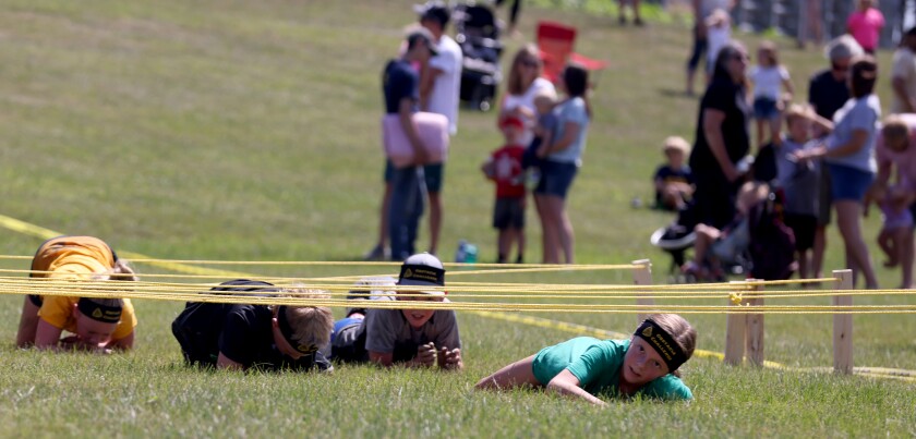 Competitors in the 11 to 13-year-old race crawl under the wire obstacle during the TriForHealth obstacle challenge during the Jackson County Fair Saturday at the Jackson Motorplex.