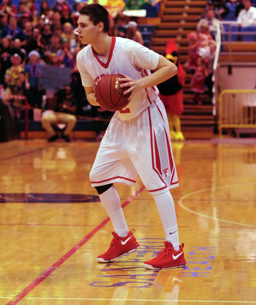 Dickinson Trinity senior forward Shawn Stoltz looks to pass against Ellendale on Thursday at the Minot State Dome. (Parker Cotton / The Dickinson Press)