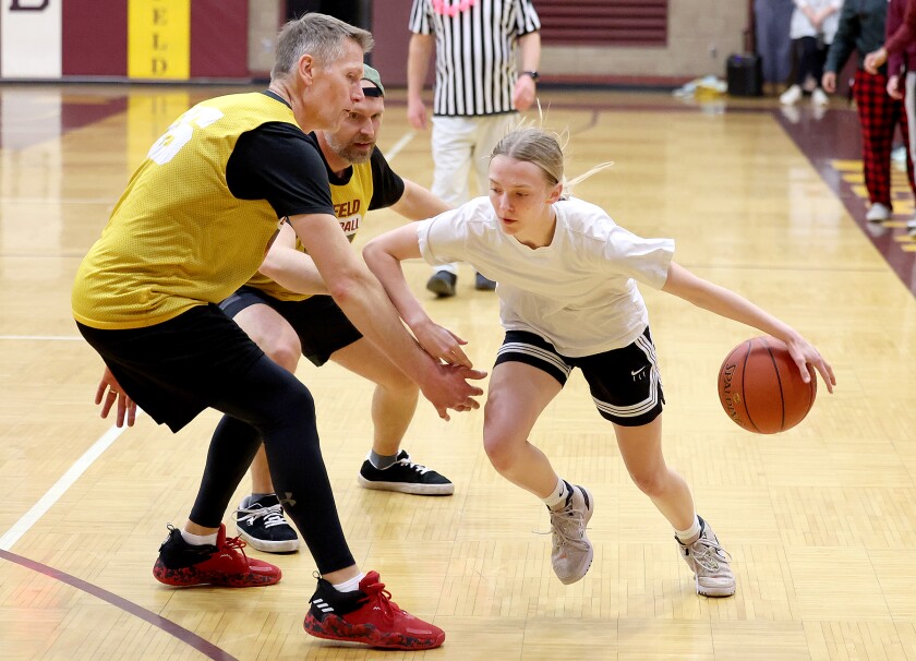 Student dribbles past coach.