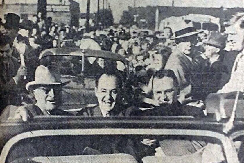 A historic photo with three male politicians riding in a vehicle.