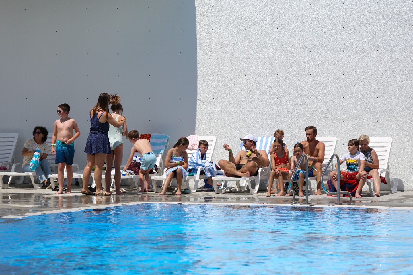 People take a break during a lifeguard pool check at the grand opening of Island Park Pool on Tuesday, June 17, 2025.