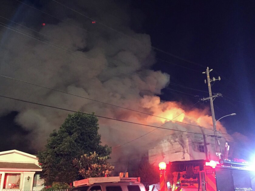 Flames rise from the top of a warehouse, which caught fire during a dance party in Oakland, Cali., Dec. 3, 2016. Seung Lee/Handout via Reuters