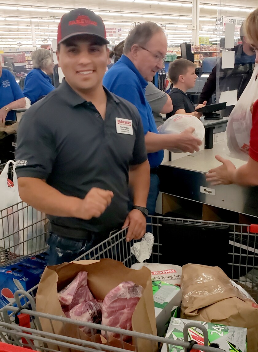 Early Risers Kiwanis members are joined by Fareway Manager Fredi Magaña in packaging up the groceries for one of the grocery dash shoppers.