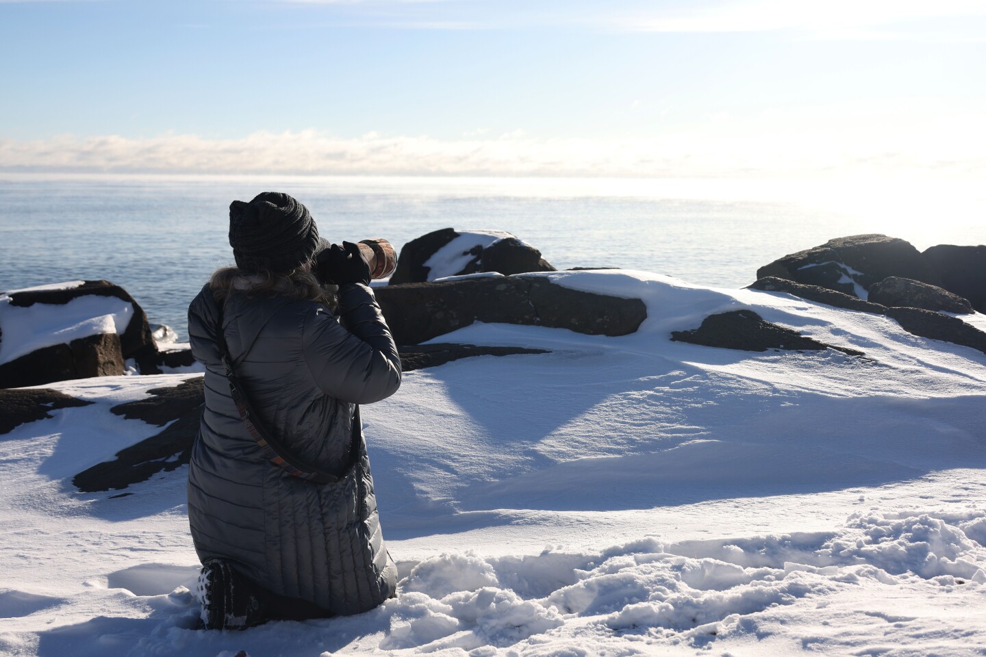 Woman takes photos of sea smoke