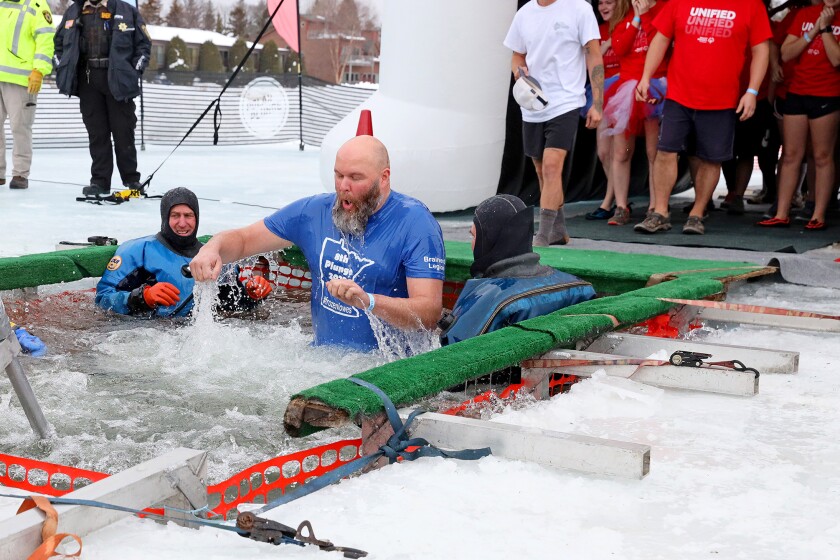 People jump into the water during the Polar Plunge event on Pelican Lake.