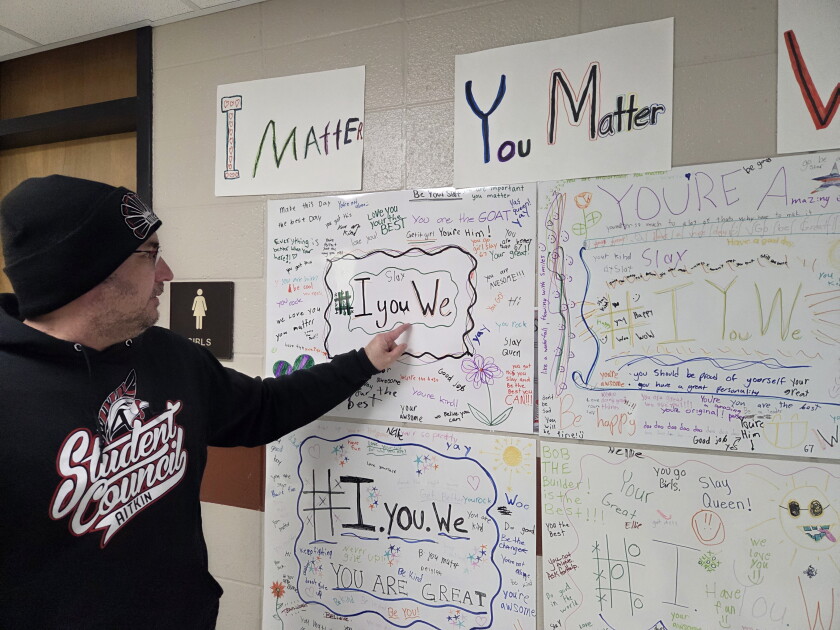 Man points to posters saying #IyouMe